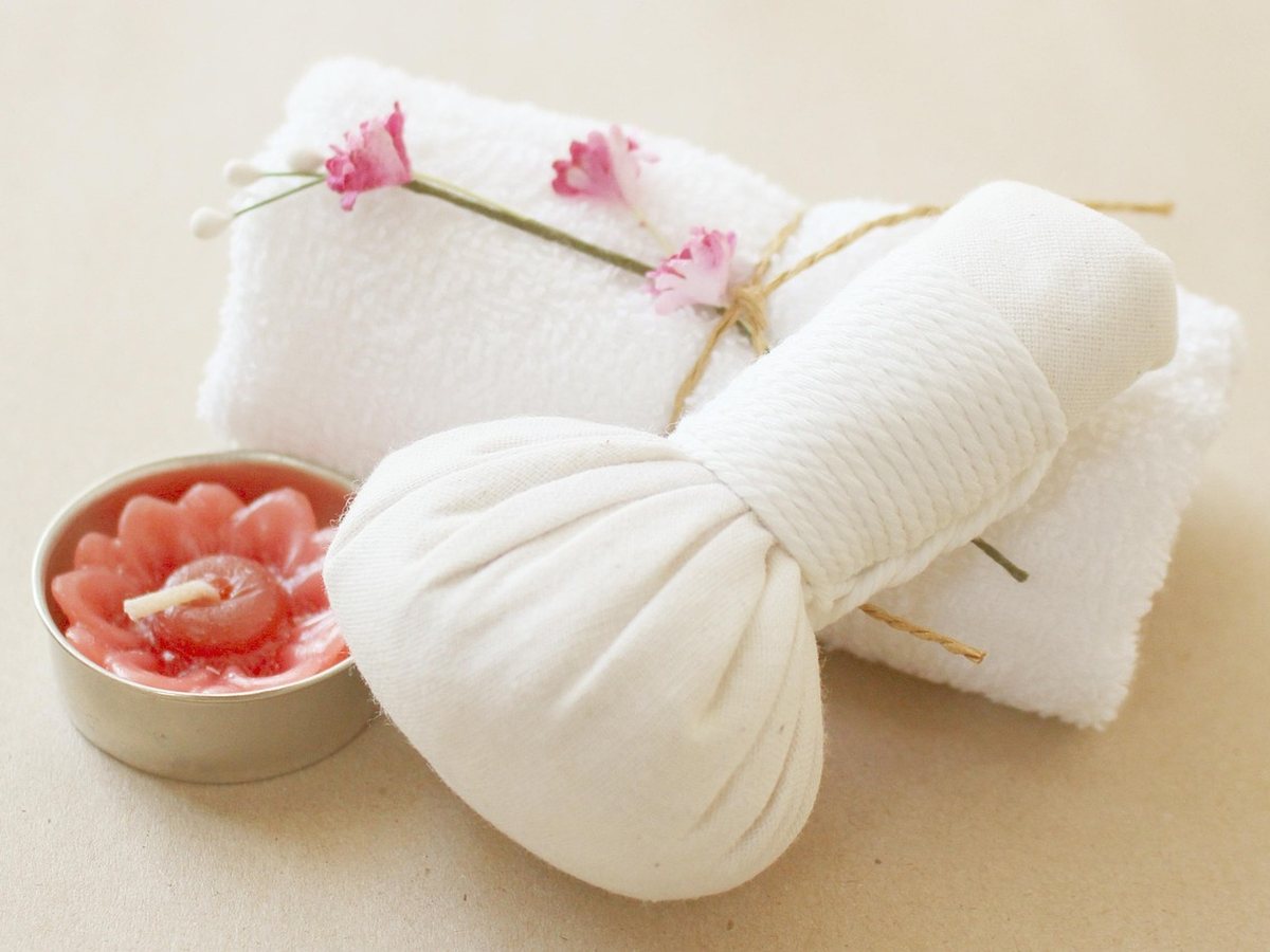 Compresses aux herbes, bougie et serviette pour un rituel bien-être